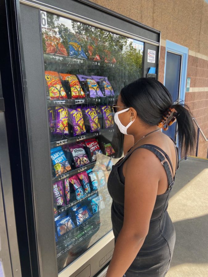 A student is angry at the vending machine because it did not give out food after the student paid.