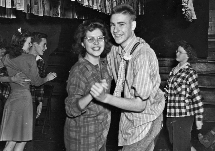 A couple is seen having fun at their casual high school dance.