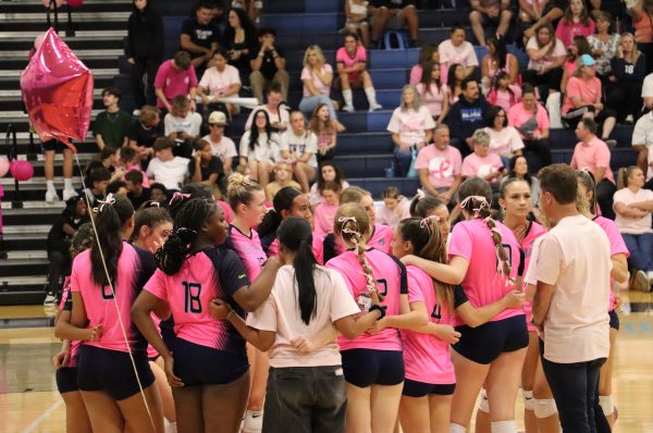 Centennial’s volleyball team huddles during the intense ‘Dig Pink’ match